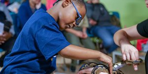 Boy touching a snake in the Digital Demo Studio.