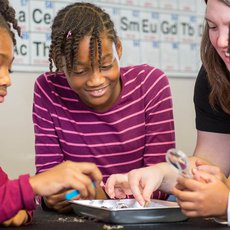 Children examining owl pellets with a team member.